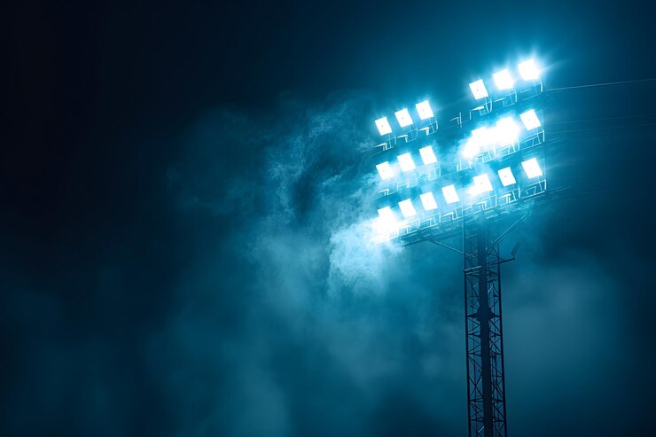 Las brillantes luces del estadio iluminan un cielo nocturno con niebla