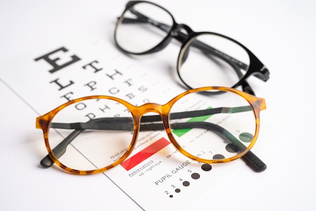Foto brille auf der augenprüfung prüfungstabelle zur überprüfung der sehgenauigkeit des lesens