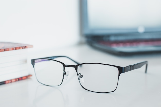 Brille mit Buch und Laptop