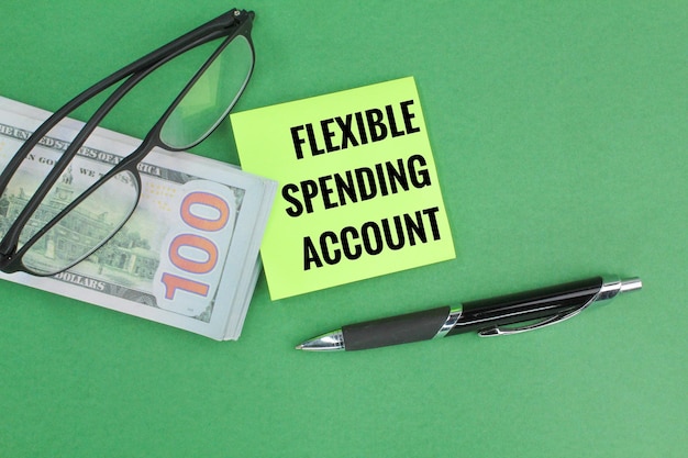 Brille, Papiergeld und Stift mit den Worten Flexible Spending Account oder FSA