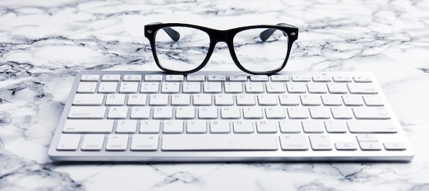 Brillen auf einem Schreibtisch oder einer Büroszene mit Tastatur