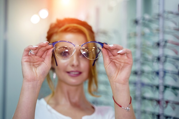 Brillen-Nahaufnahme. Brille in Frauenhänden. Brille präsentieren. Hineinzoomen