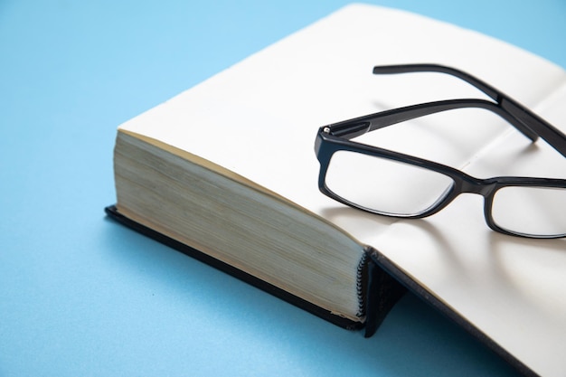 Foto brillen und buch auf blauem hintergrund