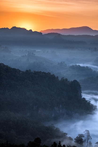 Brillo del amanecer en la montaña en el valle de niebla