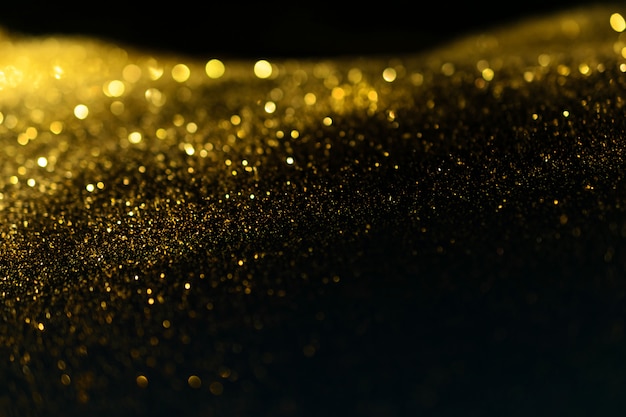 El brillo enciende el fondo del grunge, el brillo del oro defocused fondo abstracto de las luces del centelleo.