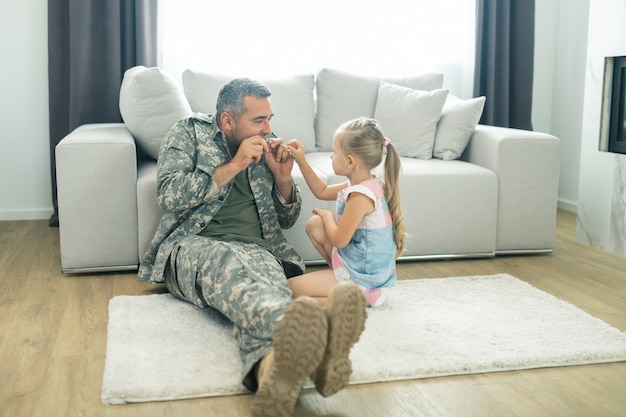 Brincando com a filha. oficial militar se sentindo feliz ao brincar com a filha durante as férias