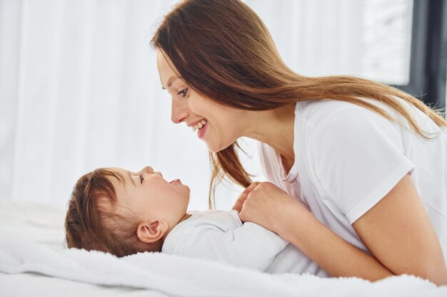 Brincando com a mãe com sua filha está dentro de casa juntos