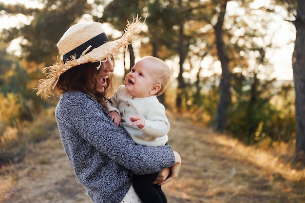 Brincando juntos Jovem mãe com seu bebê descansa ao ar livre na temporada de outono