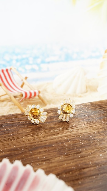Brincos de diamante de ouro amarelo isolados no fundo da praia