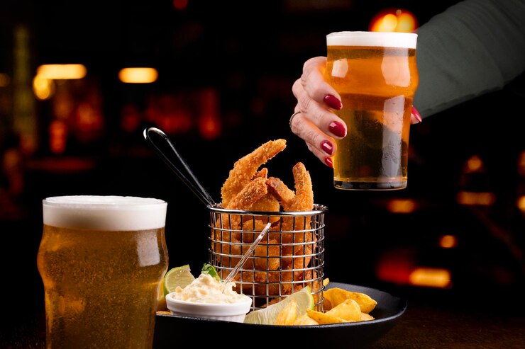 Foto brindando com cerveja e camarões fritos com batatas rústicas no bar fundo desfocado