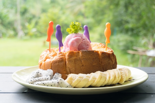 Foto brinde de mel. pão torrado com manteiga. coberto com mel, banana e frutas