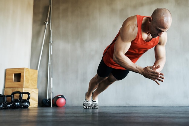 Bringt sein Training auf die nächste Stufe. Aufnahme eines Mannes, der im Fitnessstudio Übungen macht.