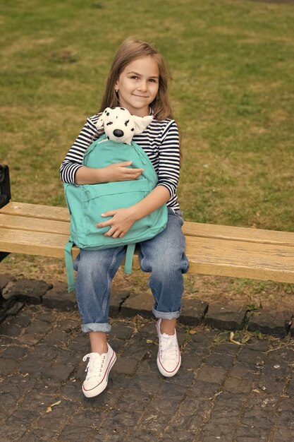 Brinque bem, fique gentil Criança pré-escolar segura cachorro de brinquedo na bolsa Criança da pré-escola Educação pré-escolar Creche e berçário Jardim de infância e creche Cuidados pós-escola Crescer acabou de começar