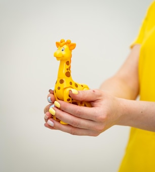 Brinquedo alegre segurando nas mãos de mulher mãos de mulher seguram brinquedo