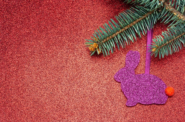 Brinquedo artesanal de Natal roxo de feltro na árvore de Natal em um fundo vermelho