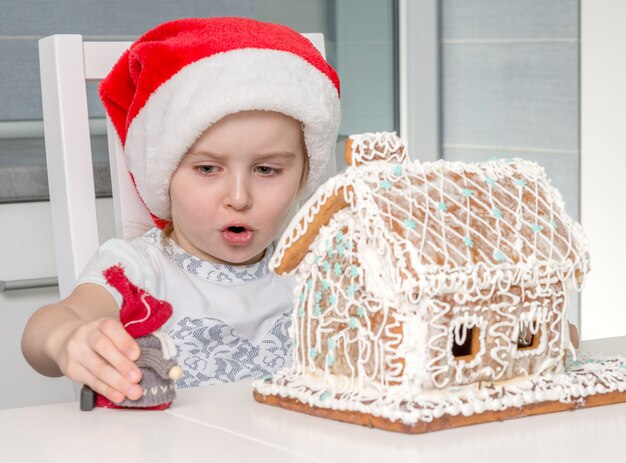 Brinquedo bonitinho menina perto de casa de biscoito