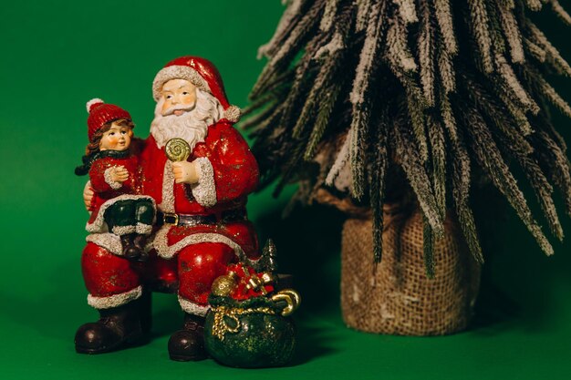 Brinquedo de árvore de Natal de gesso em forma de Papai Noel em um fundo verde
