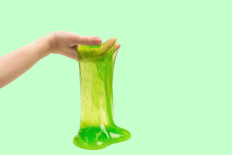 Foto brinquedo de limo verde na mão de uma mulher isolado no branco