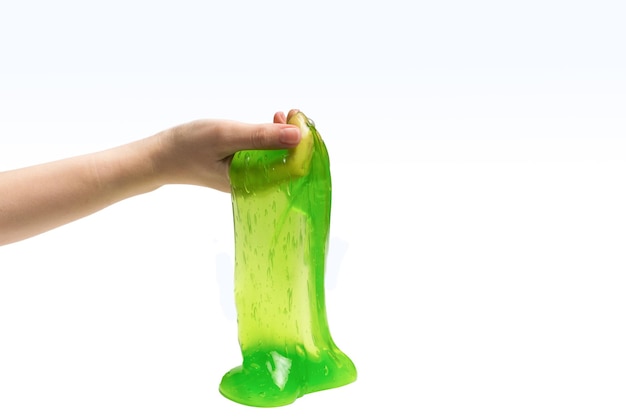 Brinquedo de lodo verde na mão da mulher isolado no branco.