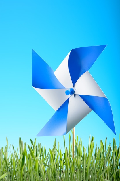 Foto brinquedo do moinho de vento na grama verde contra o céu