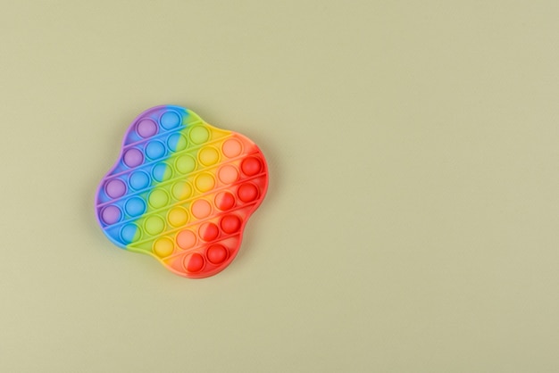 Brinquedo infantil colorido e brilhante feito de silicone projetado para aliviar o estresse em uma superfície de papel de uma tonelada