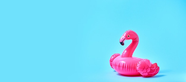 Brinquedo inflável piscina flamingo rosa sobre fundo azul. Conceito mínimo criativo. Bandeira.