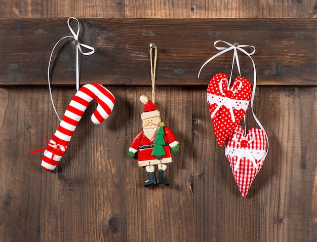 Brinquedos artesanais de decoração de natal que pairam sobre fundo de madeira rústico. foto nostálgica estilo retro