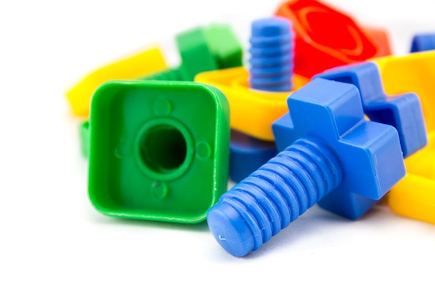Brinquedos coloridos e engraçados de nozes e parafusos isolados no fundo branco