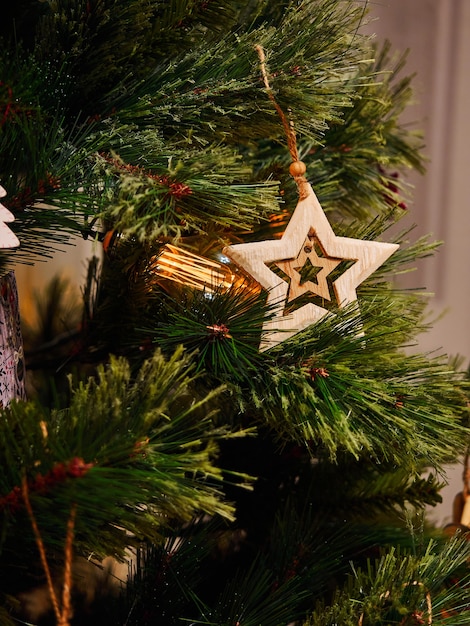 Brinquedos com estrelas de madeira e lanternas na árvore de natal