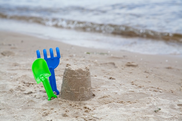 Brinquedos de areia na praia perto da água