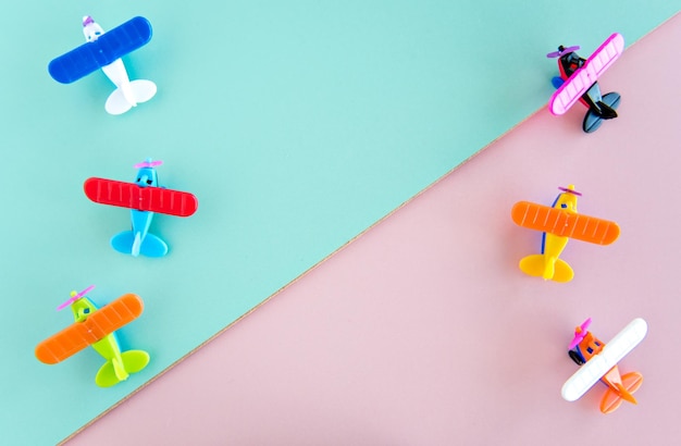 Brinquedos de avião de plástico em fundo verde e rosa