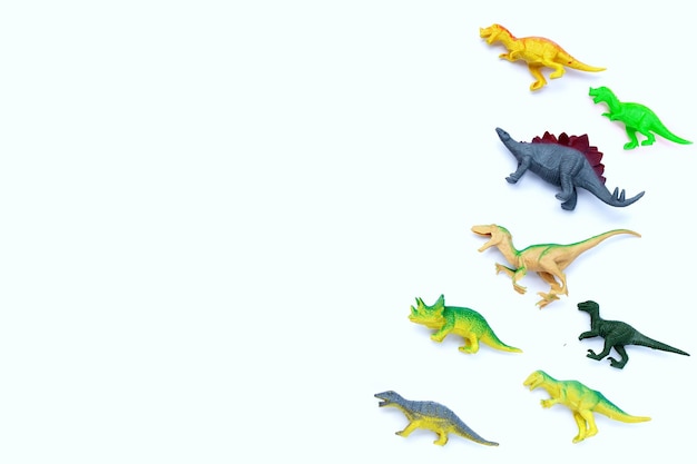 Brinquedos de dinossauro de plástico na vista superior de fundo branco