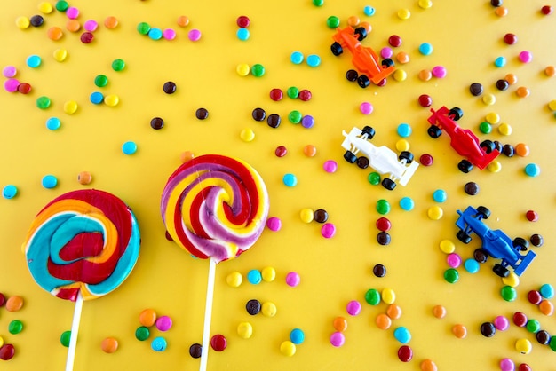 Brinquedos de doces infantis pirulitos e doces coloridos em um fundo amarelo