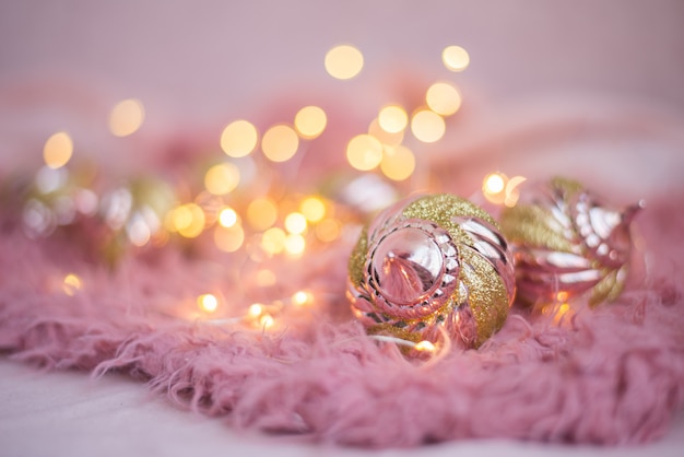 Brinquedos de Natal cores rosa e ouro em luzes de Natal em um cobertor fofo rosa