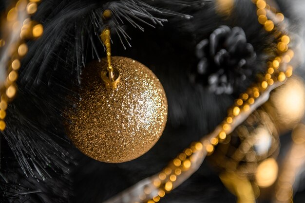 Brinquedos de Natal dourados na árvore preta