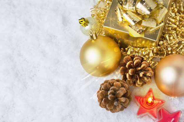 Brinquedos de Natal dourados na neve com luz brilhante e espaço de cópia bokeh