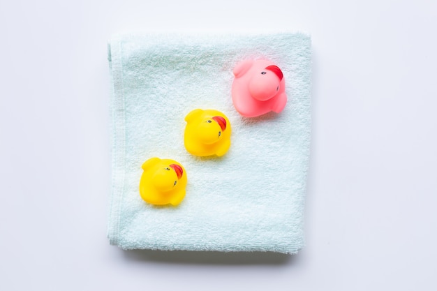 Brinquedos de pato rosa e amarelo na toalha verde macia