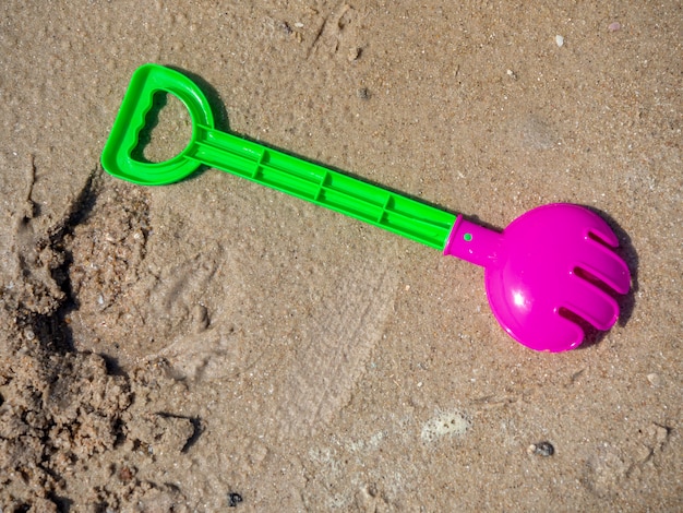 Brinquedos de praia infantil colorido sobre fundo de areia