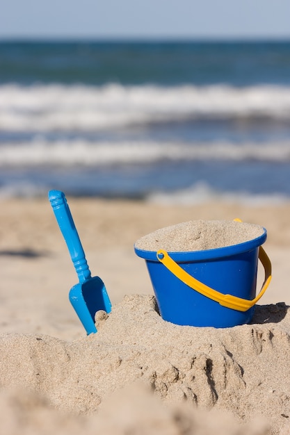 brinquedos de praia para crianças um balde e uma pá na areia atividades ao ar livre para crianças na praia