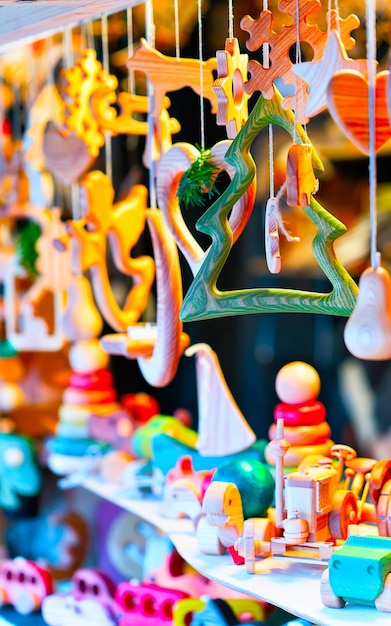 Brinquedos e decorações de madeira da árvore de Natal no mercado de Natal no inverno Riga, Letónia. Decoração da Feira do Advento e barracas com itens de artesanato no Bazar. Rua Natal e feira de férias na cidade europeia.