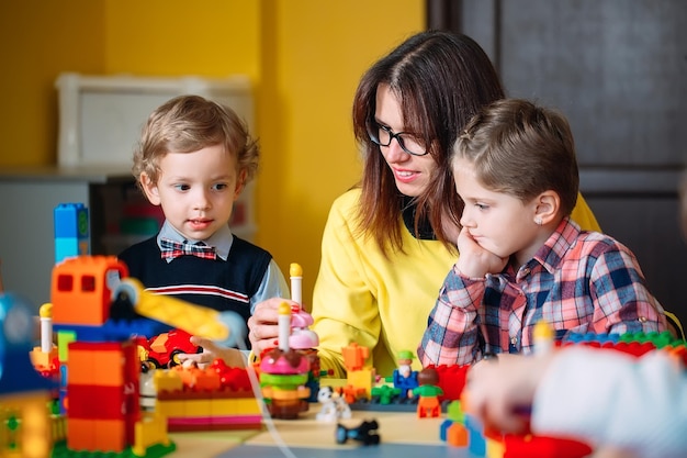 Brinquedos educativos para crianças de pré-escola e jardim de infância. criança brincando com blocos de construção na aula.