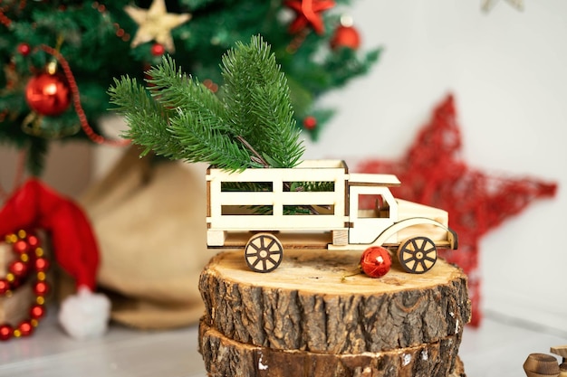 Brinquedos infantis e presentes no chão sob a árvore de Natal Cartão postal com tilke rústico caminhão de madeira chapéu de papai noel e cupcakes de madeira