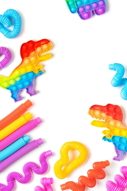 Brinquedos infantis modernos - tubos coloridos e pop-it sobre fundo branco com espaço de cópia. Conjunto de diferentes formas e cores de cachimbo ondulado e brinquedos de dedo de agitação.