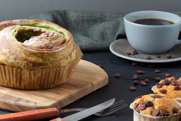 Brioche aus Pistazien gefüllt mit Schokoladen- und Vanille-Muffins, serviert mit schwarzem Kaffee.