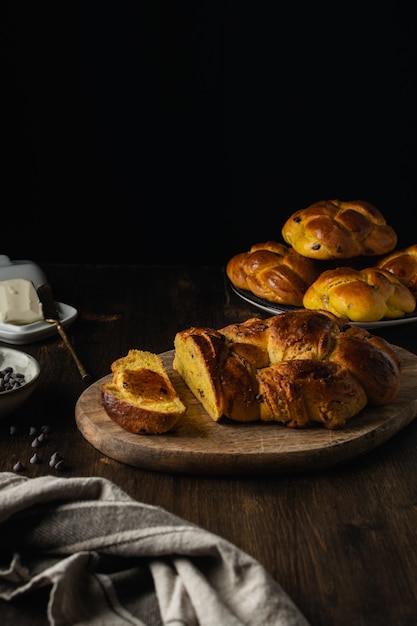 Brioche recién horneado con chispas de chocolate sobre fondo de madera oscura