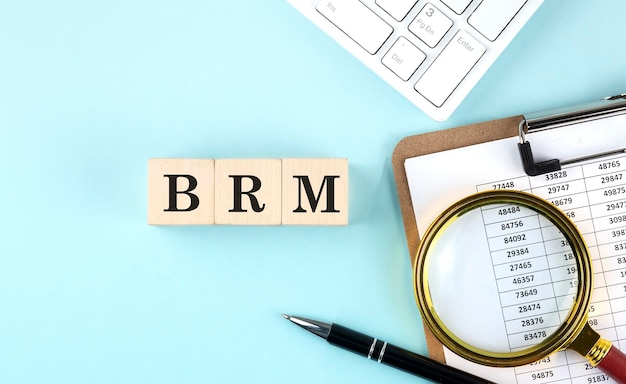 BRM Business Reference Model Wort auf Holzwürfeln auf blauem Hintergrund mit Diagramm und Tastatur
