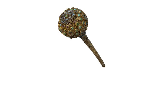 Un broche en forma de flor de oro y verde con diamantes.