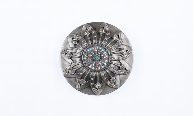 un broche de plata con un diseño azul y verde en él