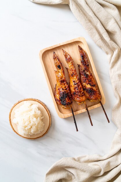 brocheta de alitas de pollo a la parrilla o barbacoa con arroz glutinoso