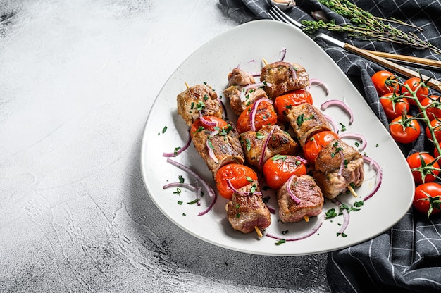 Brocheta de cerdo en brochetas con tomate